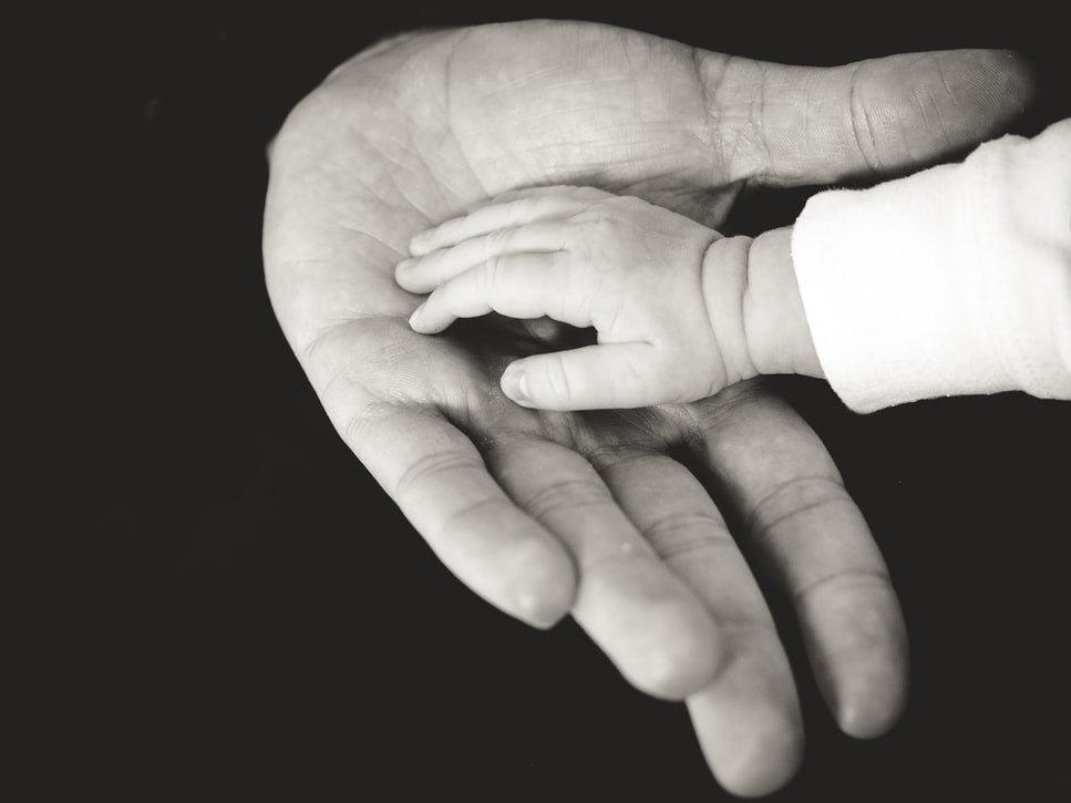 Image of baby's hand in an adult's hand