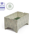 An image of a DockATot Kind Essential Bassinet - Willow Boughs, jpma certified, tree planted bassinet with a botanical print. The bassinet features ornately crafted pedestal feet and is designed for infant safety and comfort.
