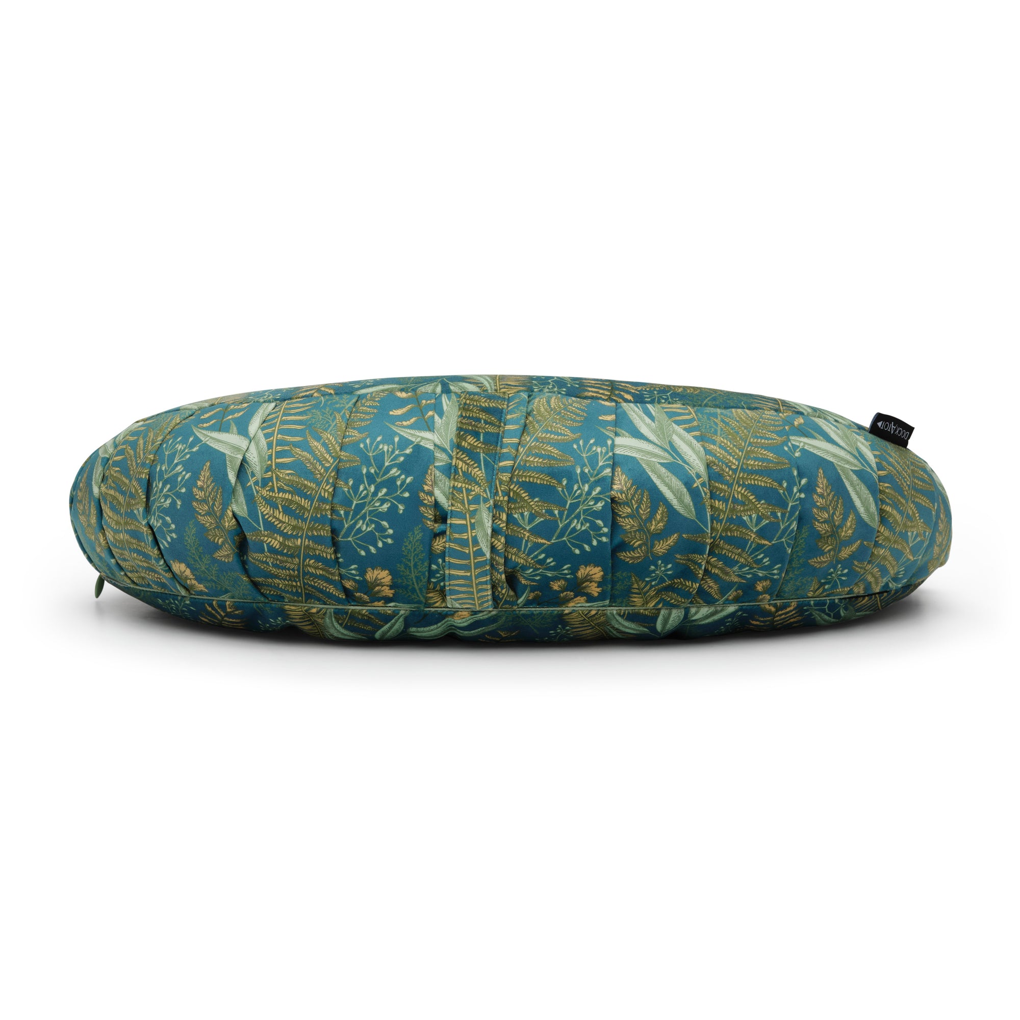 A LAST CHANCE: La Maman Wedge - Navy Night Falls featuring a tropical leaf pattern with various shades of green, blue, and yellow on a white background. The pillow has a small black tag on one side, offers lumbar support.